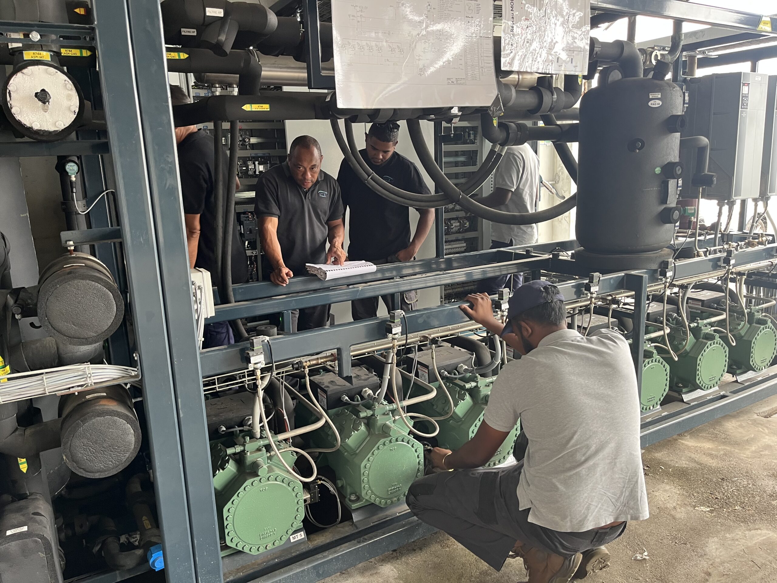 Des techniciens en train de travailler sur des machines de froid