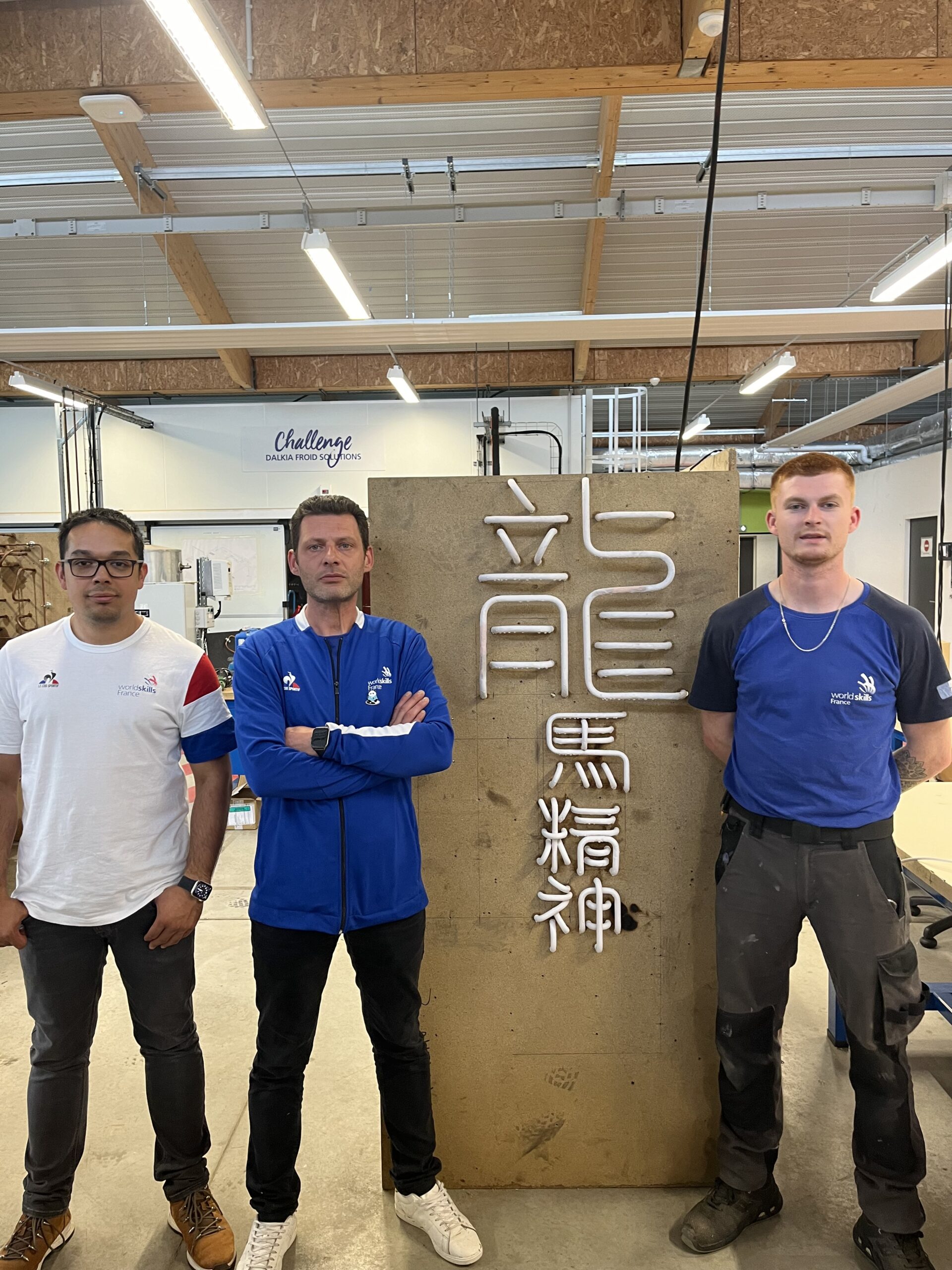 Simon Lor-Saw, Mickaël Bellet et Samuel Fazilleau devant un panneau avec des caractères chinois